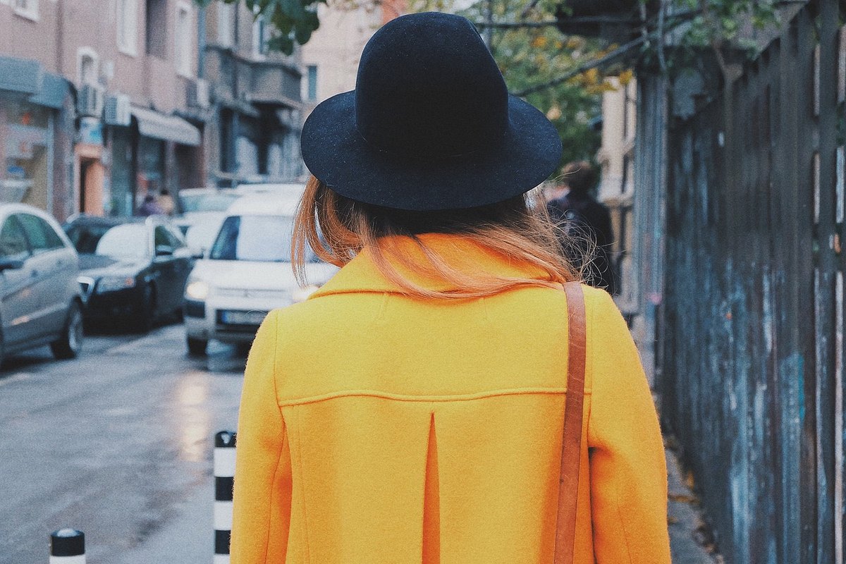 Femme de dos portant un manteau en laine jaune moutarde
